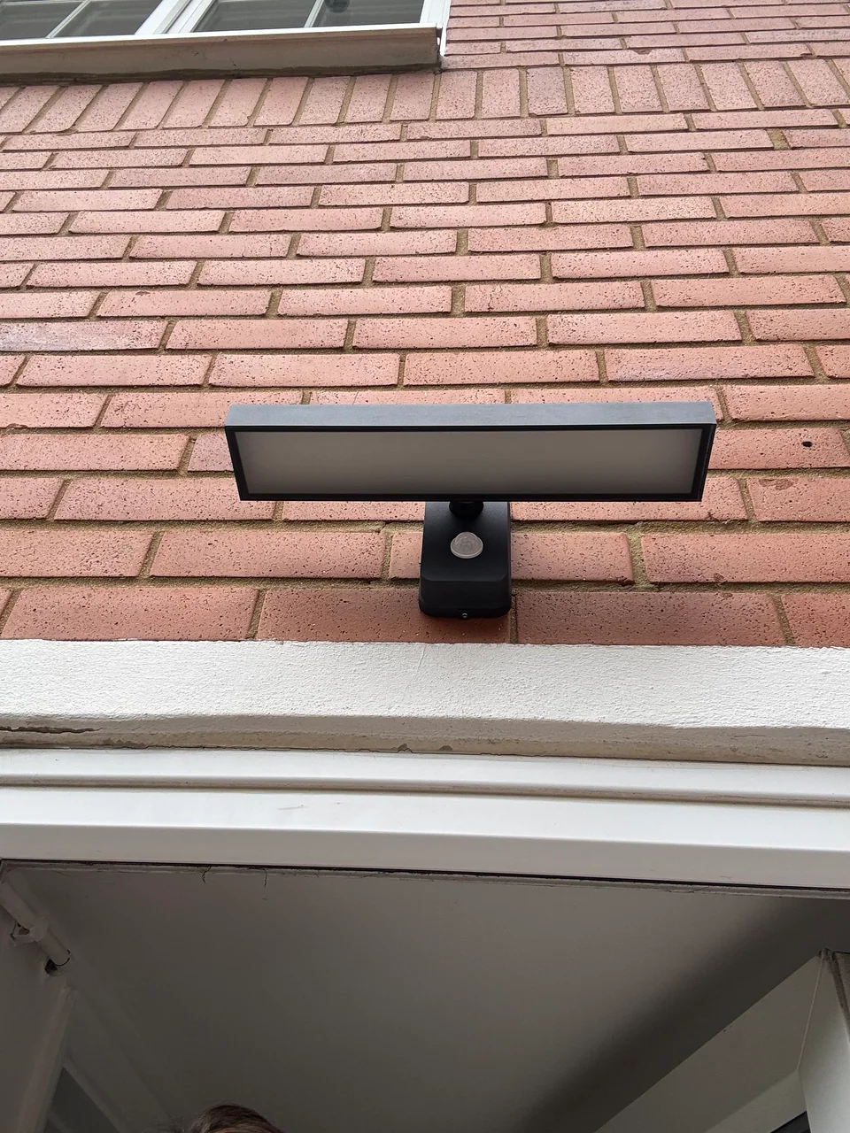 Completed external security light installed on rear brick wall